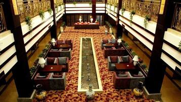 A spacious lobby with a central water feature, multiple seating areas, and a decorative railing.