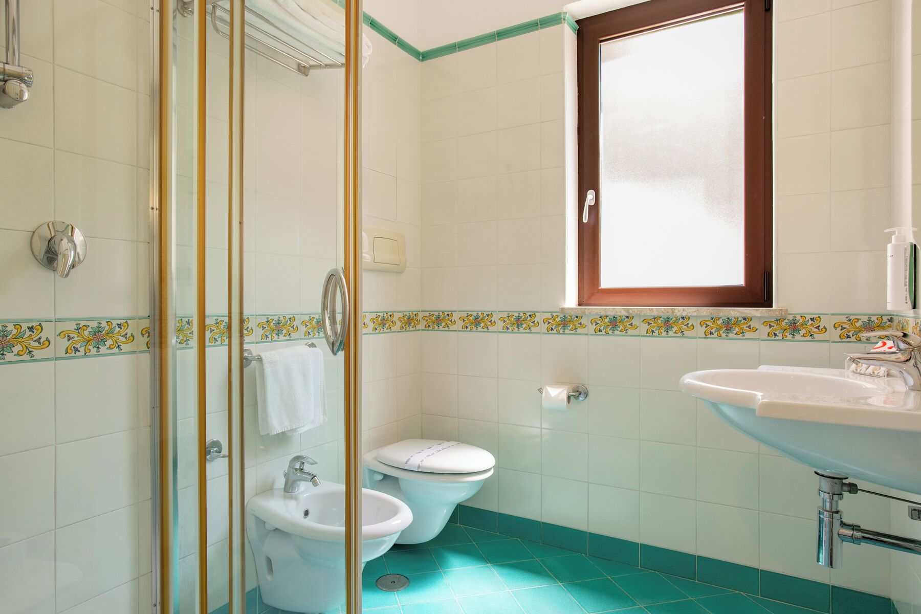 Un baño con ducha, inodoro y lavamanos.