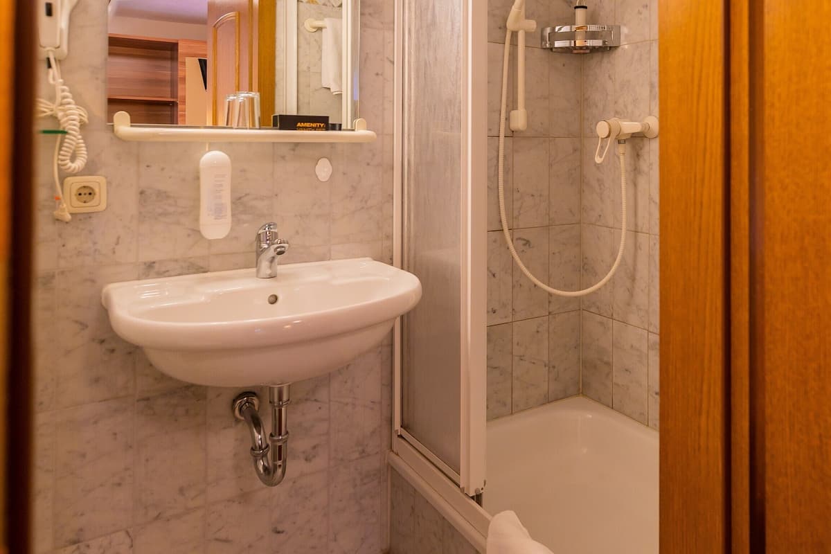 premium single room | bathroom | shower, hair dryer, towels, soap