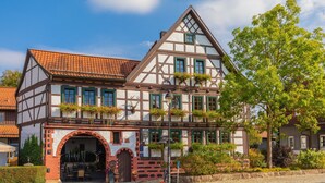A traditional half-timbered building with a prominent archway entrance, multiple windows, and a tiled roof. - Gasthaus Goldener Hirsch (Suhl)