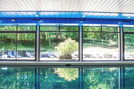 Una piscina techada, sillones reclinables de piscina