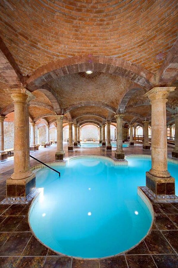 A large indoor swimming pool with a brick ceiling and columns. - Termas De San Joaquin (Ramos Arizpe)