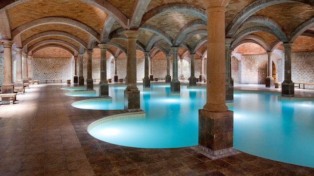 A large indoor swimming pool with multiple arches and columns, surrounded by stone walls. - Termas De San Joaquin (Ramos Arizpe)
