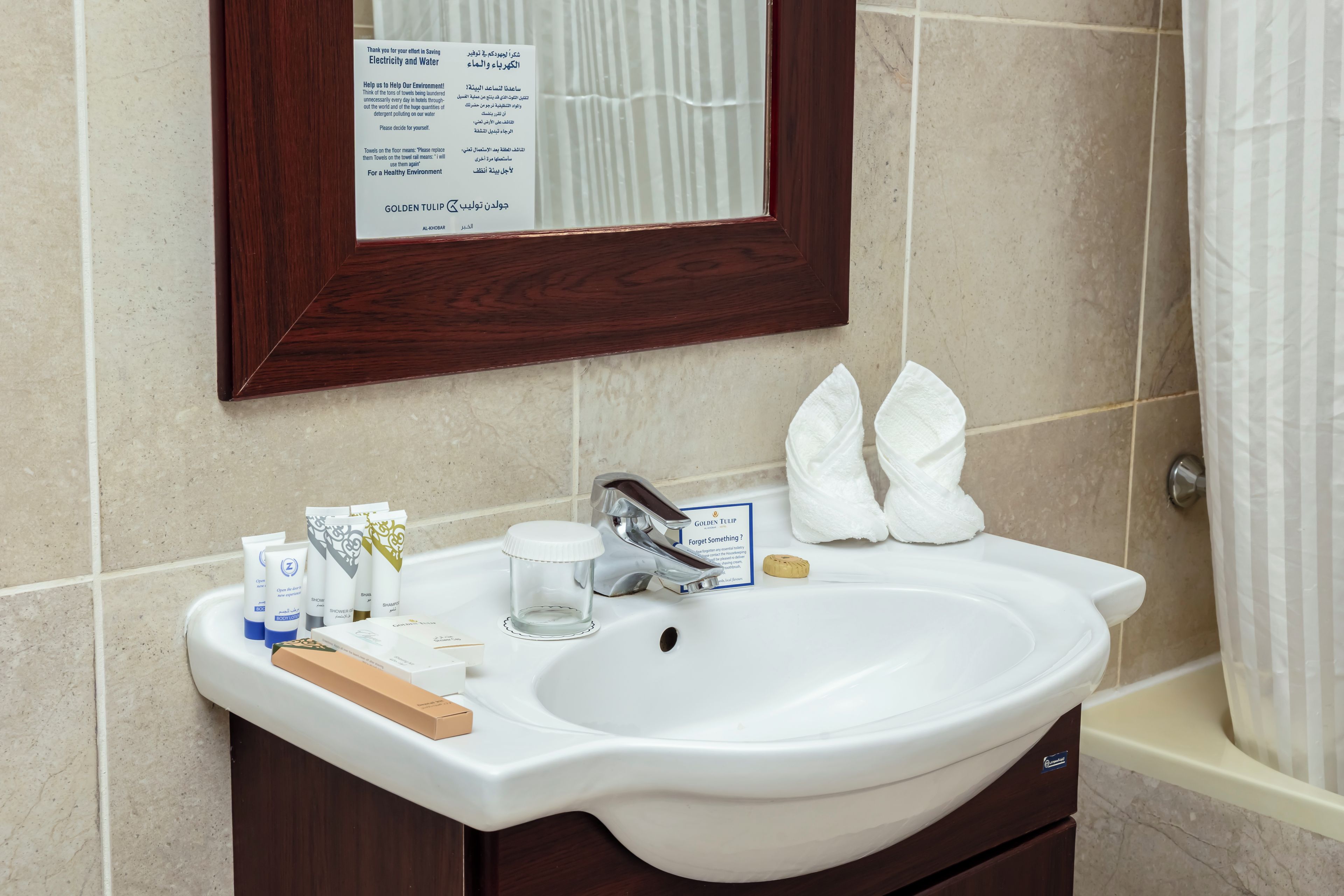 Une salle de bain avec un lavabo blanc, un miroir et des articles de toilette.