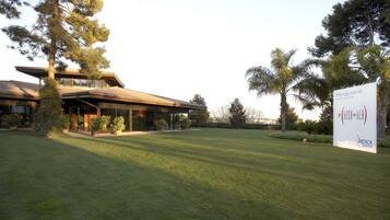 A modern building with a large lawn and potted plants.
