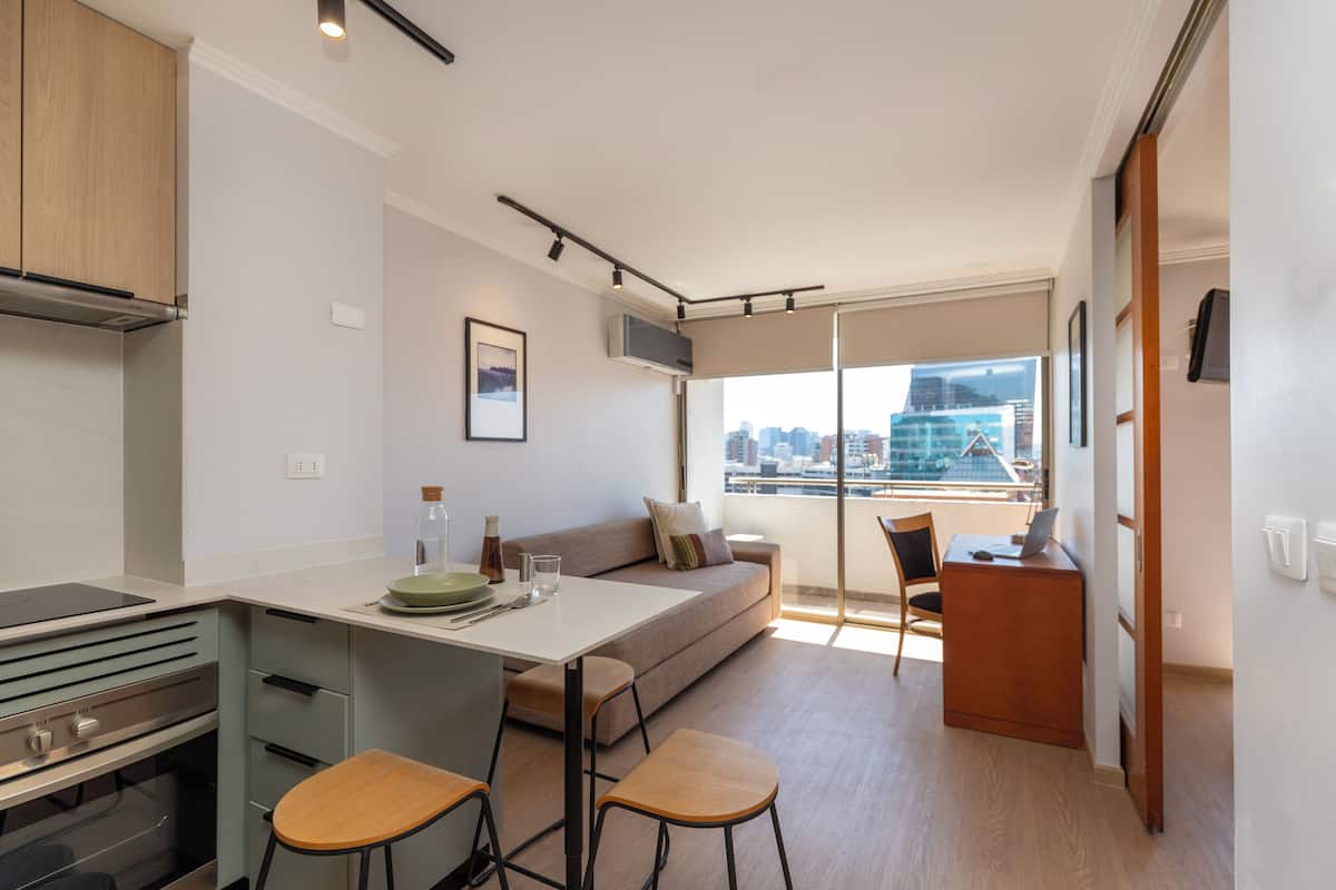 Eine moderne Küche mit Essbereich, einer Couch und Blick auf die Stadt.