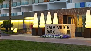 Een modern gebouw met balkons en een bord waarop 'CALA MILLOR PARK' staat.