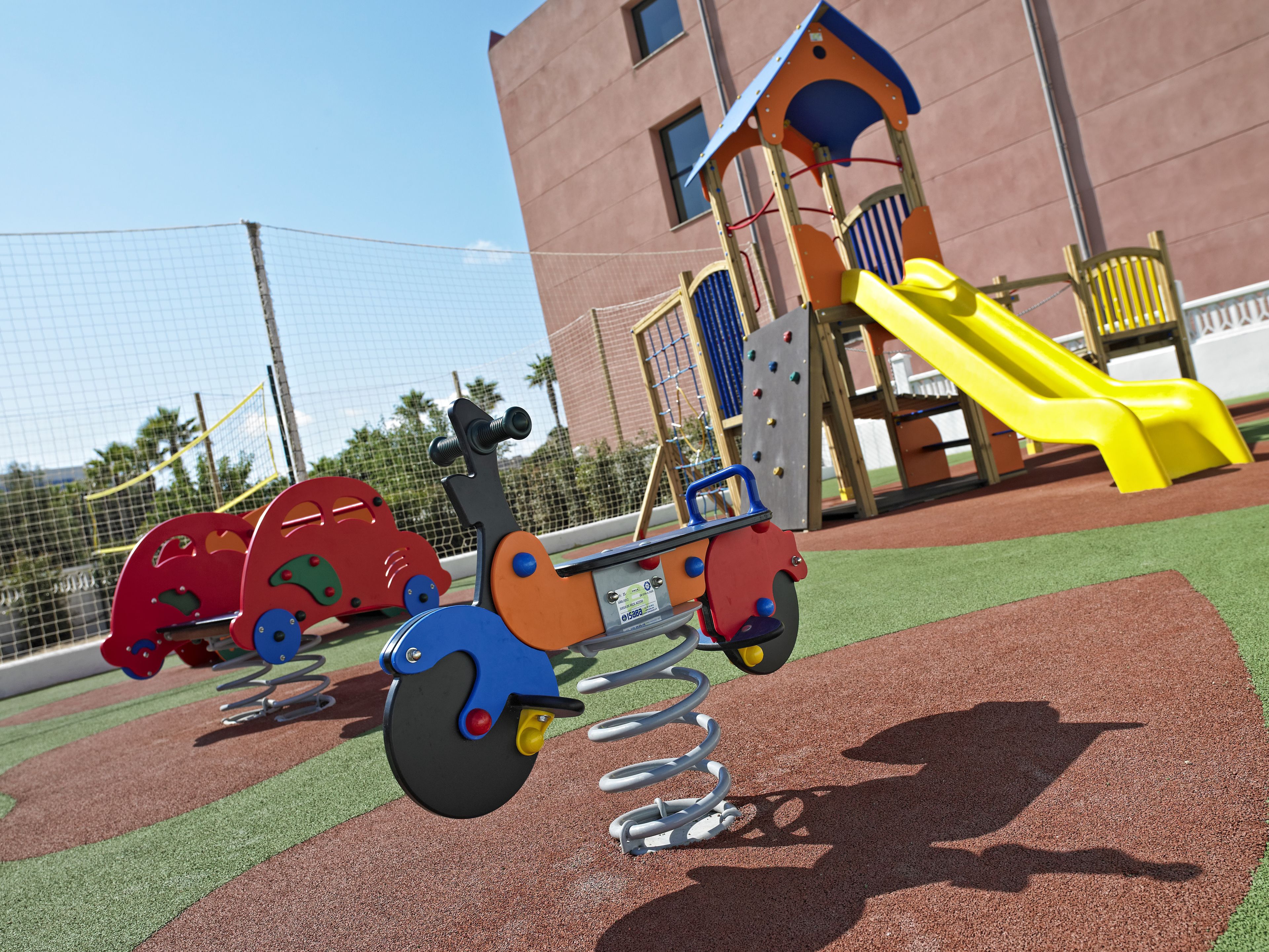 A playground with a seesaw, a slide, and a climbing structure.