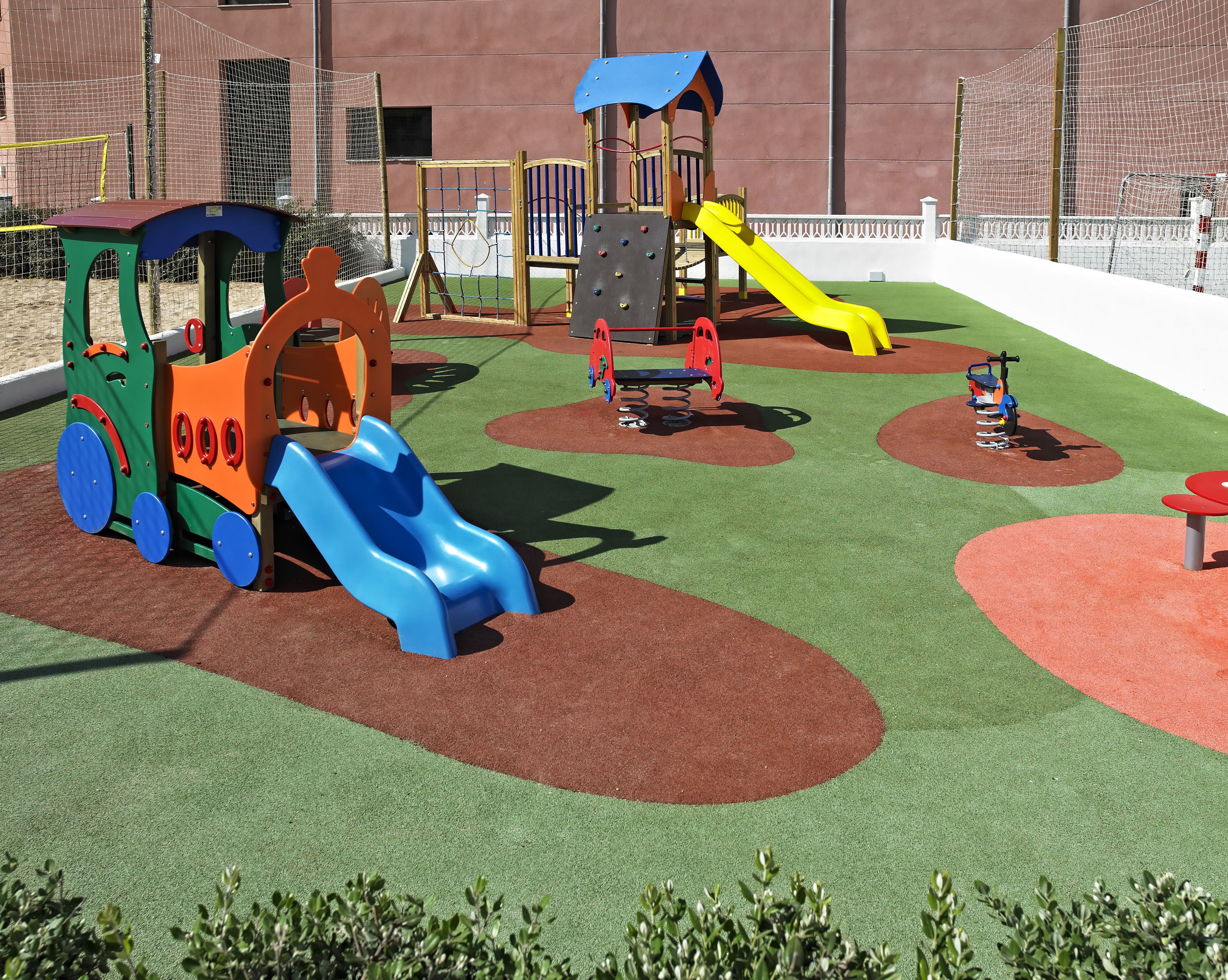 Un parque infantil con diversas estructuras de juego, incluyendo toboganes y zonas de escalada.