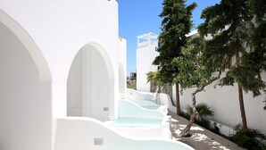 Un bâtiment blanc doté de nombreux balcons et d’un espace piscine.