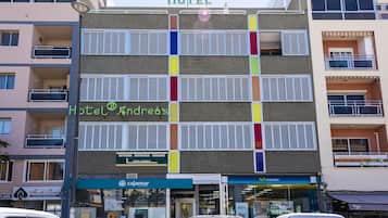 Un hotel de varios pisos con balcones, un letrero que dice 'Hotel Andredes' y una tienda 'movistar' en la planta baja.