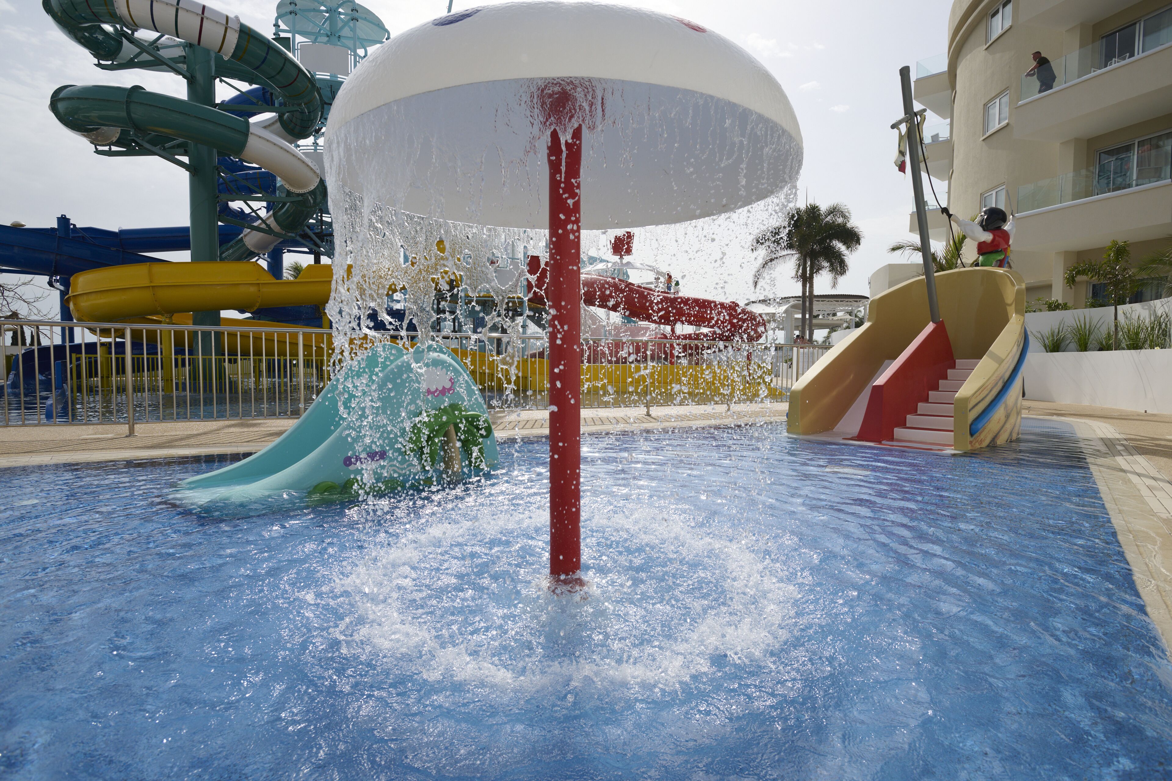 A water park with multiple slides and a large water fountain.