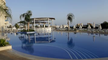 Een buitenzwembad, ligstoelen bij het zwembad