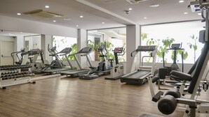 A gym with treadmills, elliptical machines, and weight benches. -  Sunrise Oasis Hotel & Waterpark (Paralimni)