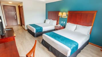 Een hotelkamer met twee bedden, een bureau en een stoel.