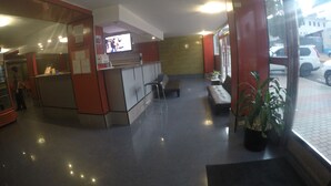 A reception area with a counter, seating, and a potted plant.