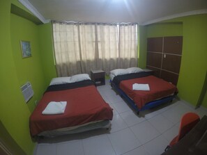 A room with two beds, a window with curtains, a radiator, and a wardrobe. - Hotel Discovery (Panama City)