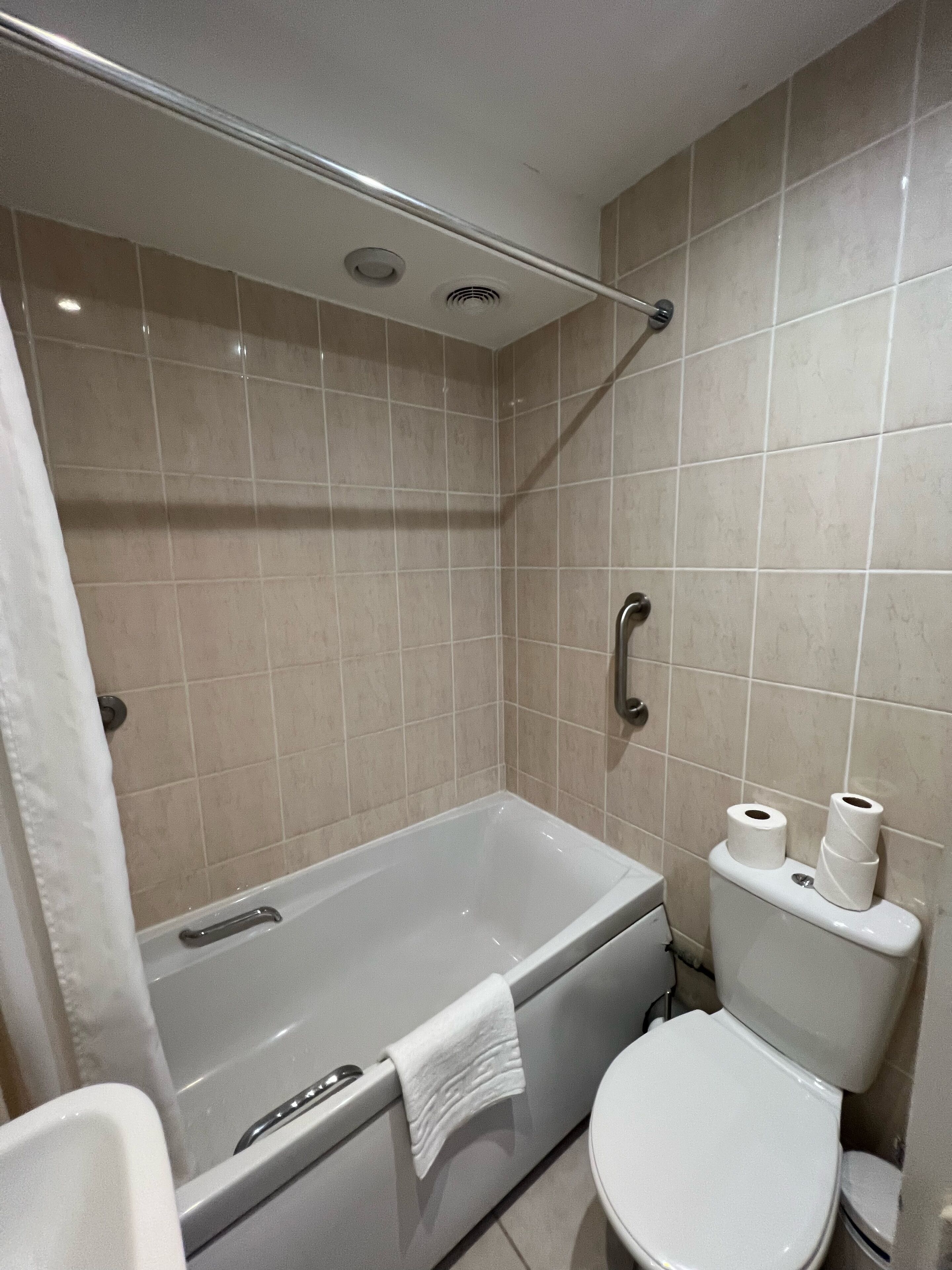 A bathroom with a bathtub, toilet, and shower area.