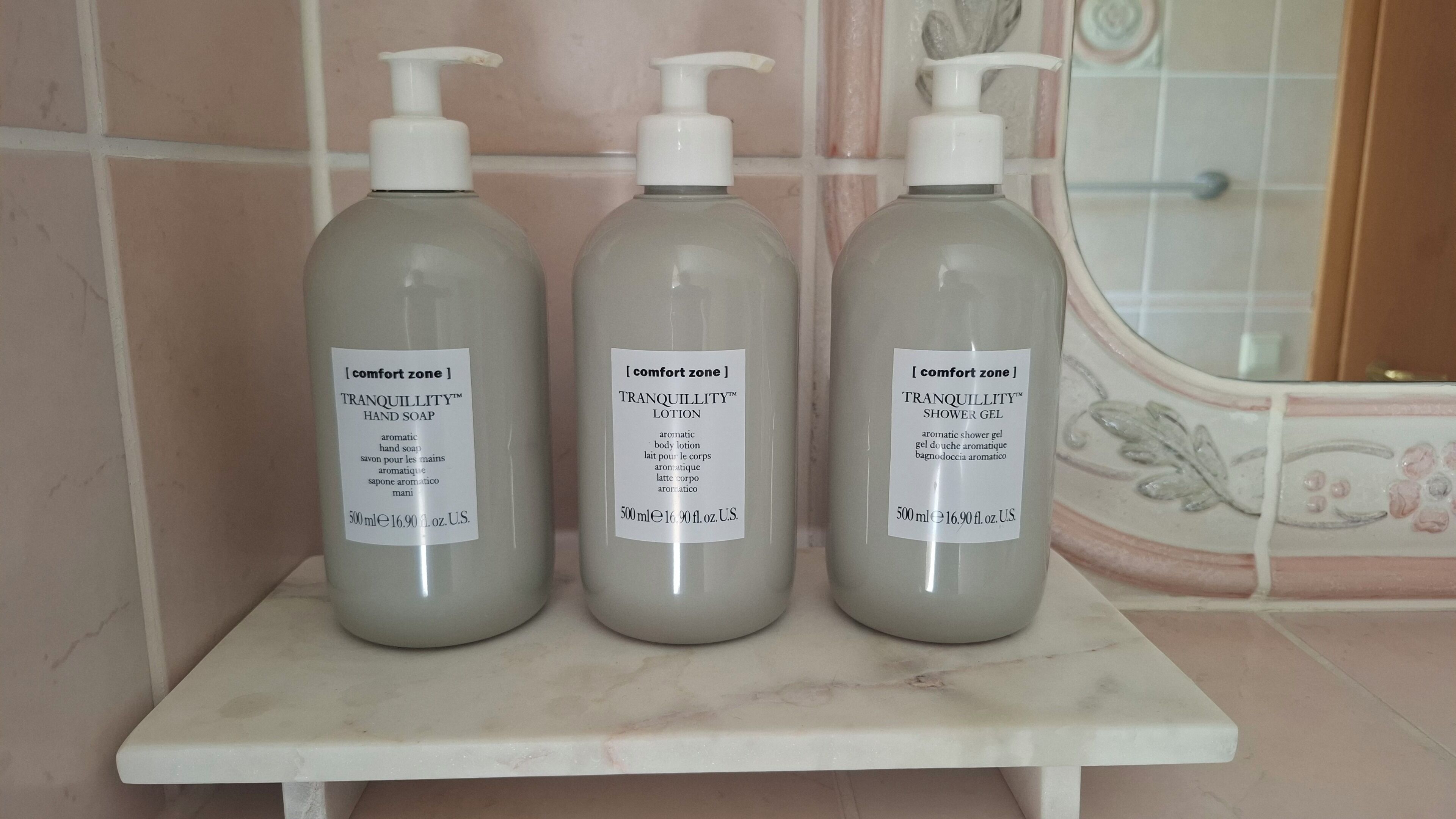 Three bottles of Tranquillity™ products on a marble shelf.