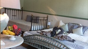 Una habitación con una cama, una mesa con fruta y una alfombra estampada.