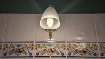A wall with a decorative tile pattern and a wall-mounted light fixture.