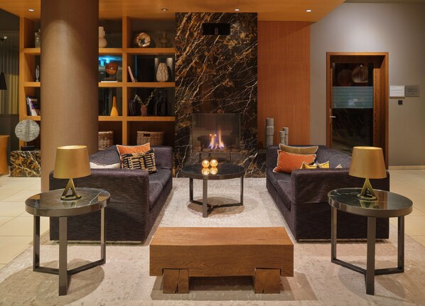 Una sala de estar moderna con chimenea, dos sofás, una mesa de centro y dos mesas auxiliares.