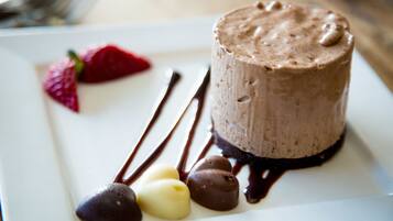 Un dessert composé de sauce au chocolat et de fraises, présenté dans une assiette.