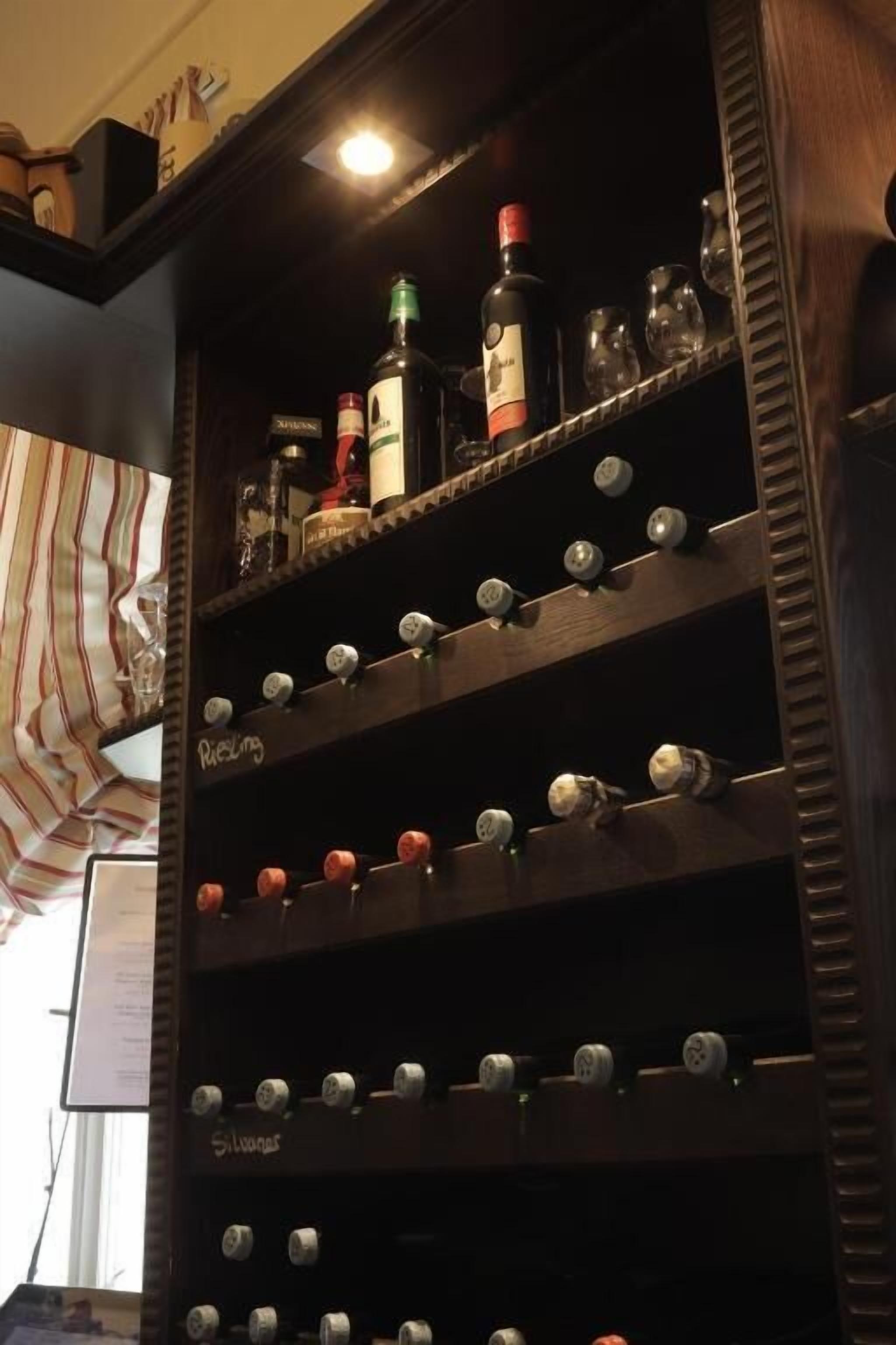 A wine rack with bottles and glasses.
