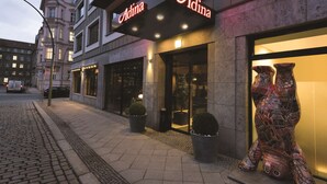 A building with a neon sign reading "Adina" and a glass door entrance. - Adina Apartment Hotel Berlin Mitte (Berlin)