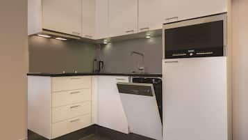 Een moderne keuken met witte kastjes, een ingebouwde vaatwasser en een roestvrijstalen oven.