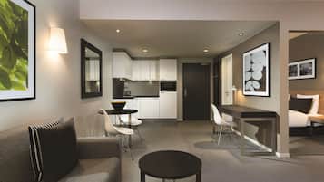 A modern living room with a sofa, a round coffee table, and a dining area with a small table and chairs.