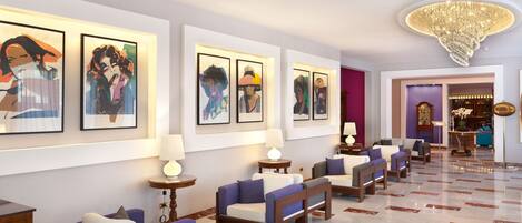 A lobby with a marble floor, sofas, and framed artwork on the walls.