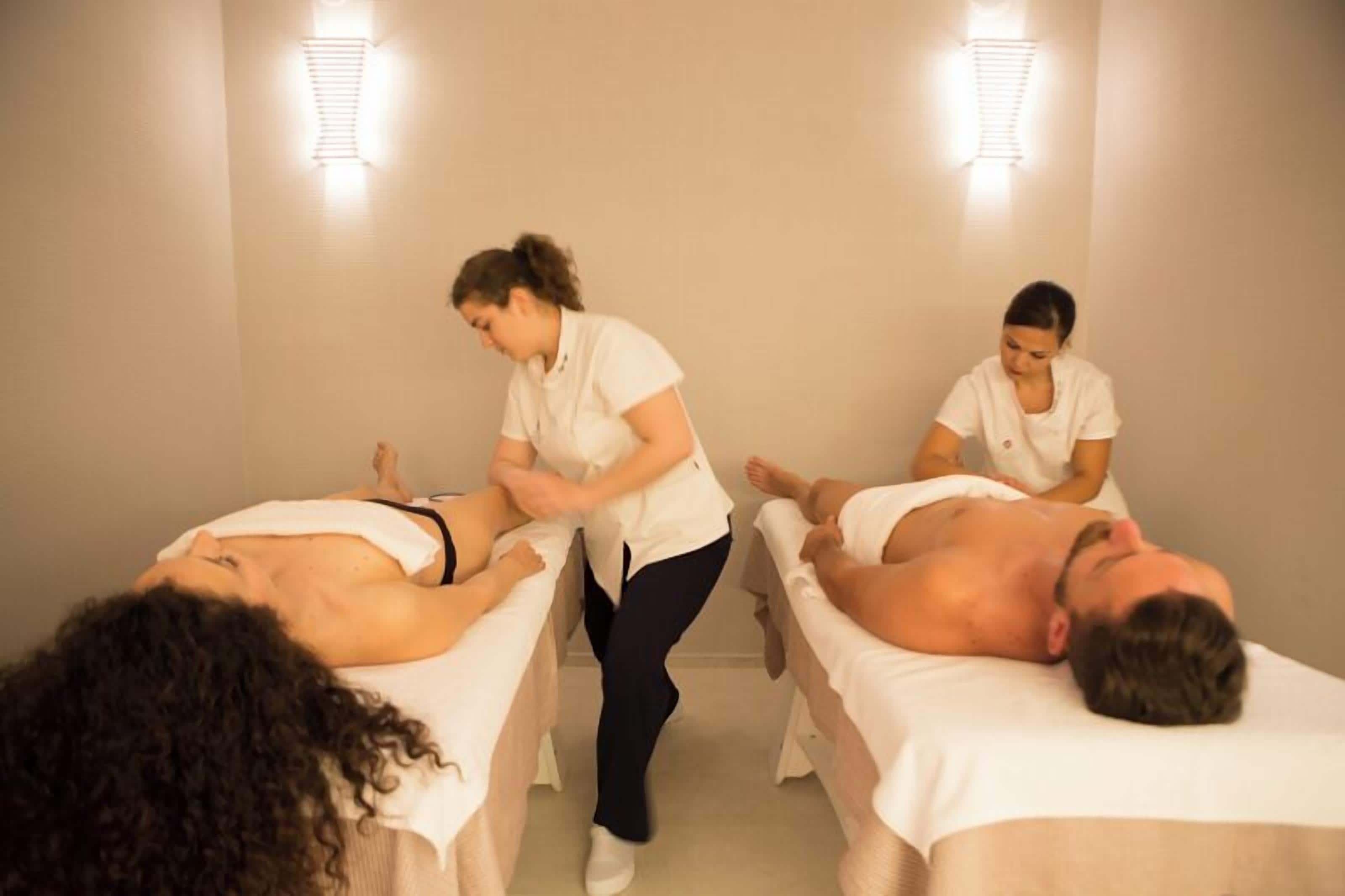 A massage therapy room with two clients receiving treatment.