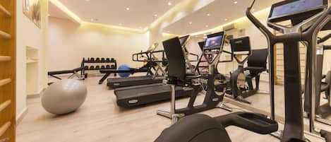 Ein Fitnessraum mit Laufbändern, Crosstrainern und Gymbällen.