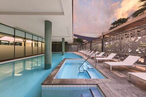 An indoor swimming pool with tiled walls and a wooden deck. - Vibe Hotel Darwin Waterfront (Darwin)