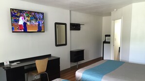 A hotel room with two beds, a desk, a chair, a TV on the wall, and a mirror. - Motel 6 Prairie Du Chien, WI (Prairie Du Chien)