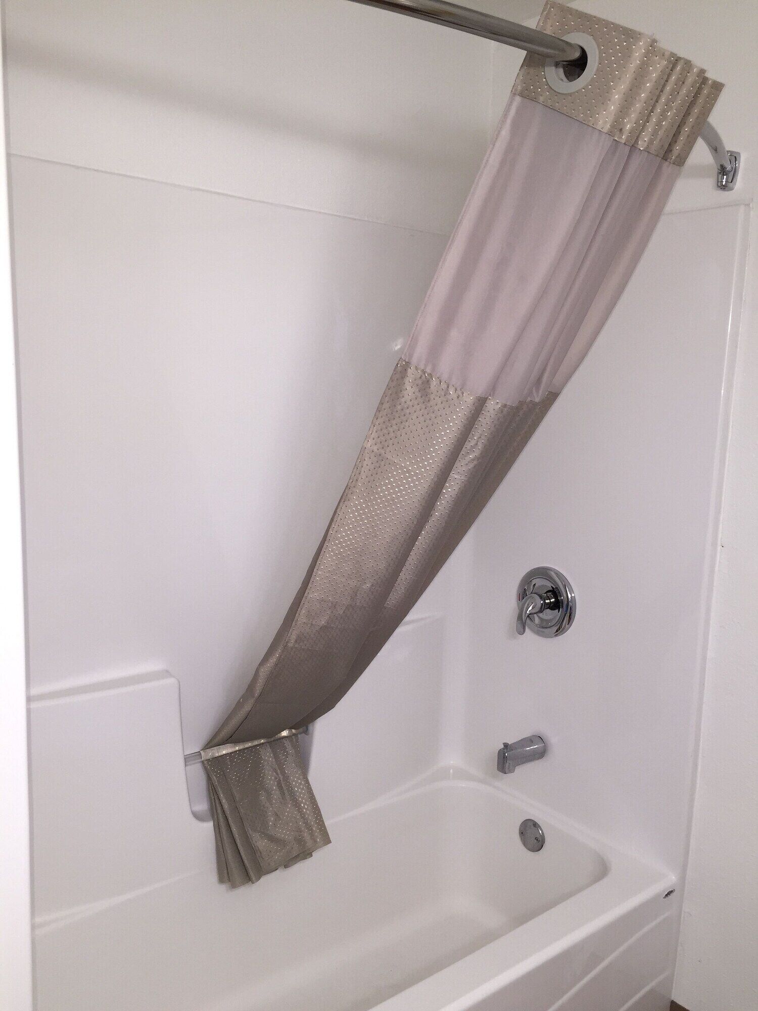 A bathtub with a shower curtain.