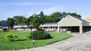 A motel with multiple rooms, a parking lot, and a small lawn area. - Motel 6 Prairie Du Chien, WI (Prairie Du Chien)