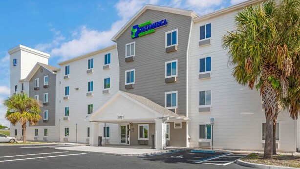 Ein 7-Eleven Express Hotel mit modernem Design, das einen  überdachten Eingang und mehrere Stockwerke bietet.