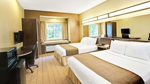A hotel room with two beds, a desk with a computer, a TV, and a window with curtains. - Microtel Inn & Suites by Wyndham Bryson City (Bryson City)