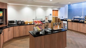 A modern breakfast bar with a variety of food options, including cereals, fruits, and beverages. - Fairfield by Marriott Inn & Suites Austin Parmer/Tech Ridge (Austin)
