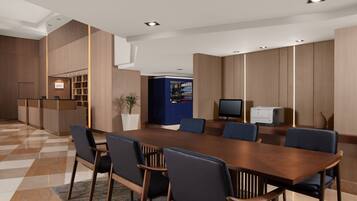 A modern conference room with a wooden table, blue chairs, and a reception desk.