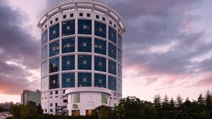 Ein Gebäude der Delta Hotels Marriott mit moderner Glasfassade, umgeben von Grünflächen und einer geschwungenen Straße.