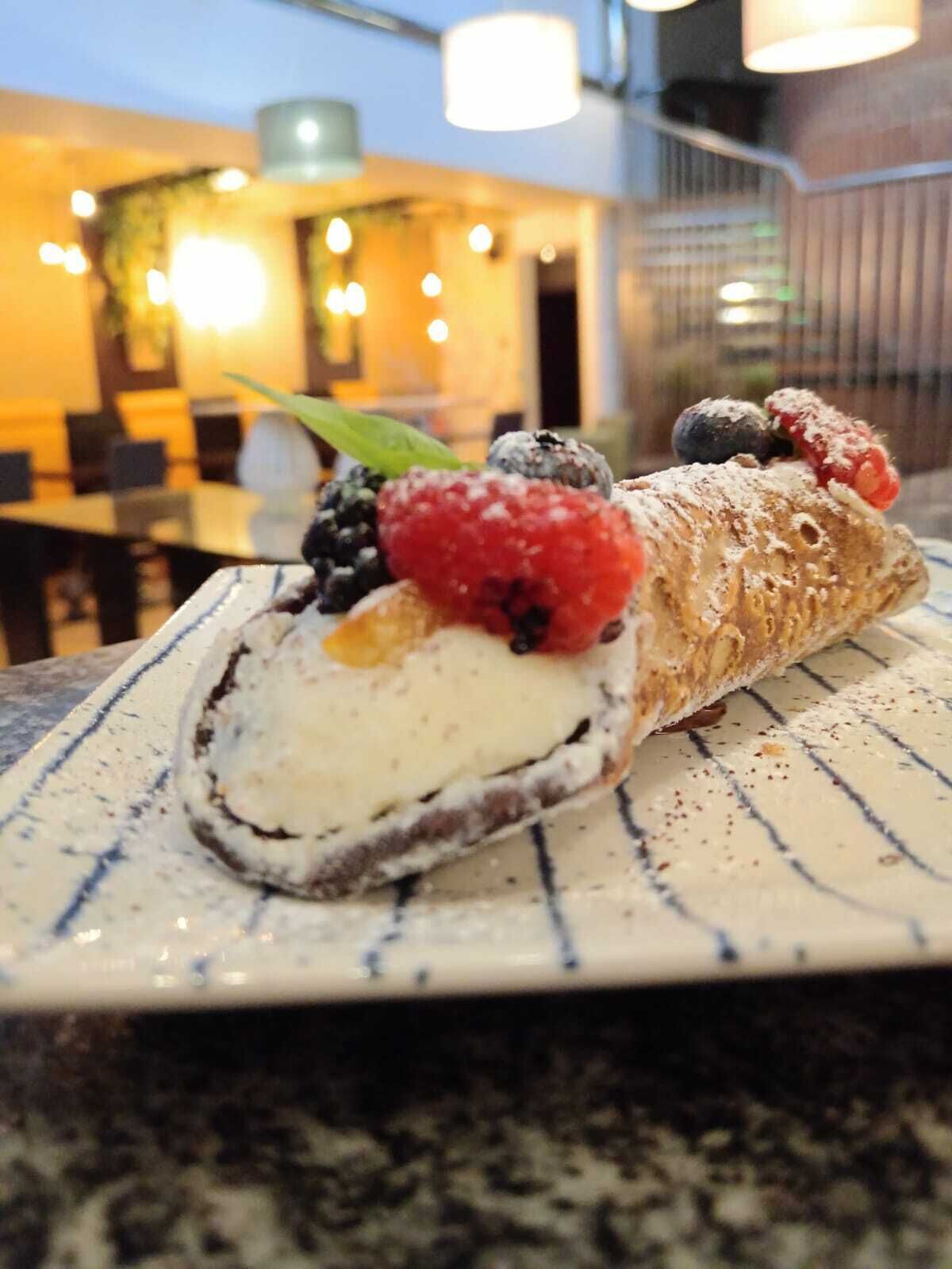 A dessert with berries and powdered sugar on a plate.