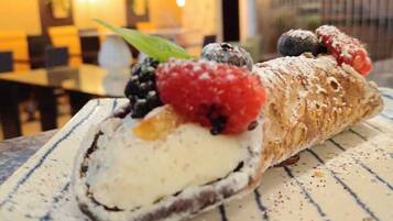 A dessert with berries and powdered sugar on a plate.