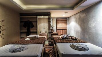 Two single beds with neatly made linens and a central seating area with a bench.