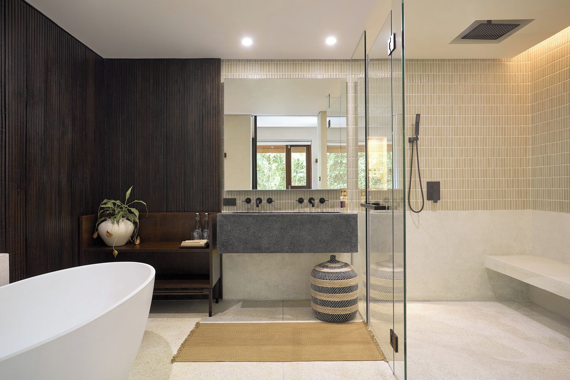 A modern bathroom with a freestanding bathtub, a glass-enclosed shower, and a vanity with a mirror.