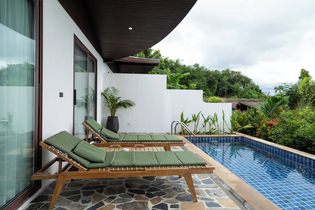 A poolside area with lounge chairs and a stone-tiled pool.