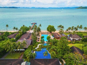 Un resort con piscina, playa y vista al océano.