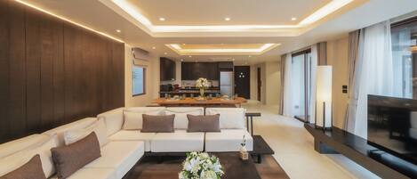 A modern living room with a sofa, coffee table, and a kitchen in the background.